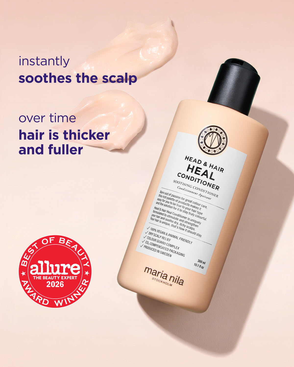 Maria Nila Head & Hair Heal Conditioner bottle in a peach-beige color with a black cap, shown on a matching beige background with two dabs of the conditioner and promotional text.