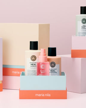 Maria Nila hair care products on a pink background
